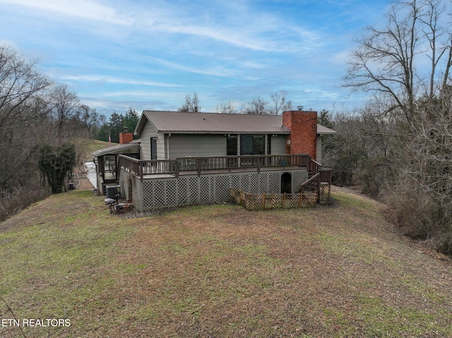 rear view of house with a wooden deck and a yard