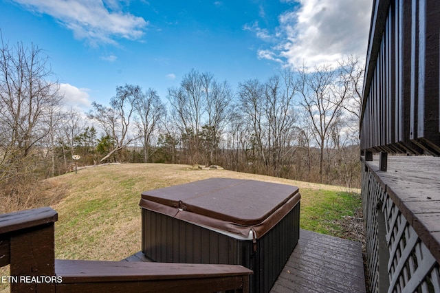 deck with a hot tub and a yard