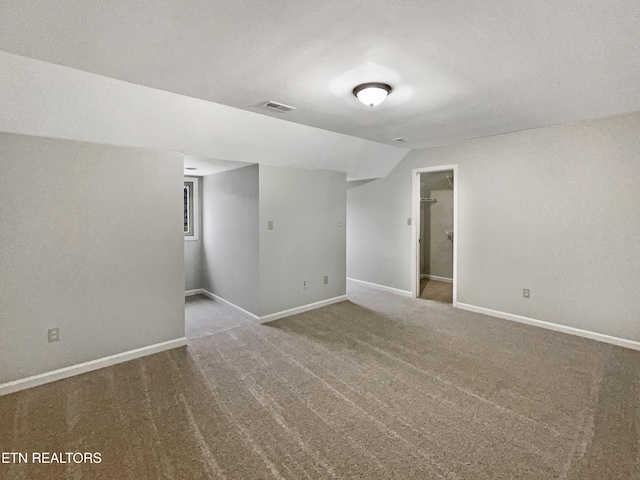 carpeted empty room featuring lofted ceiling