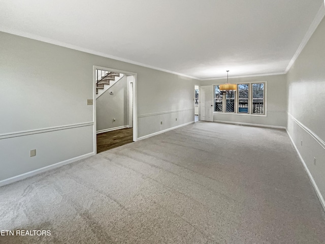 unfurnished living room with ornamental molding and carpet