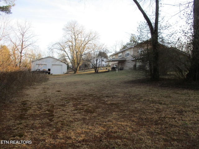 view of yard featuring a garage and an outdoor structure