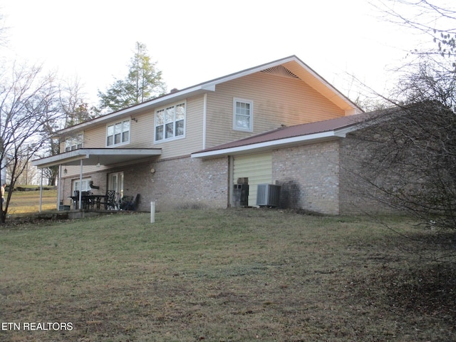 back of property featuring cooling unit and a lawn