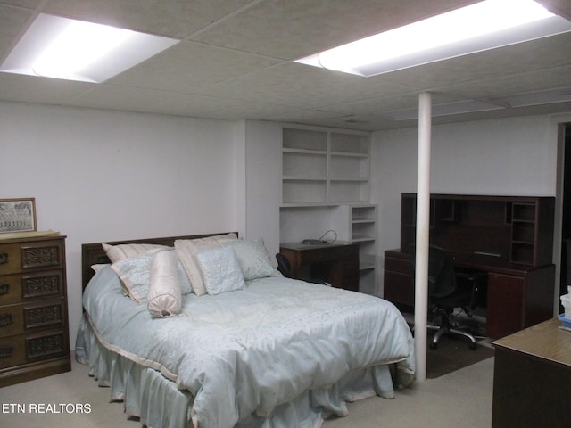 bedroom with light carpet and a paneled ceiling