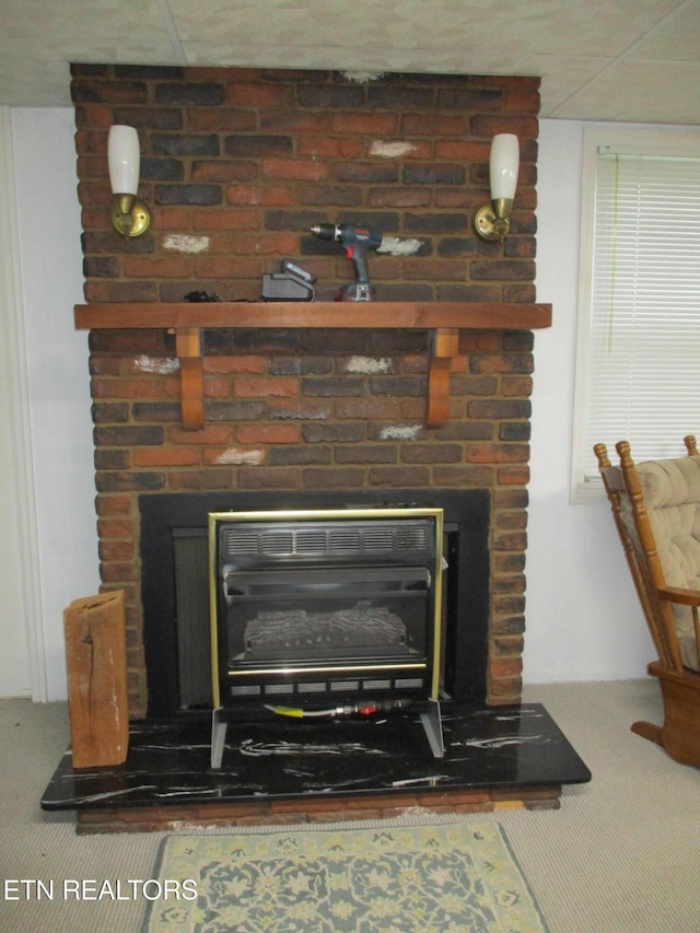 interior details with a brick fireplace and carpet