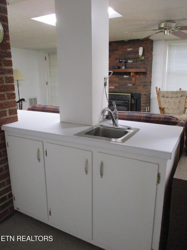 washroom with ceiling fan, sink, and a brick fireplace