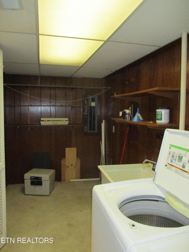 clothes washing area featuring washer / dryer, electric panel, and wooden walls