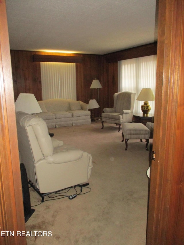 carpeted living room featuring wooden walls