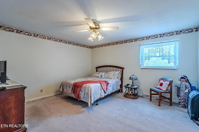 bedroom featuring ceiling fan, light colored carpet, and a textured ceiling