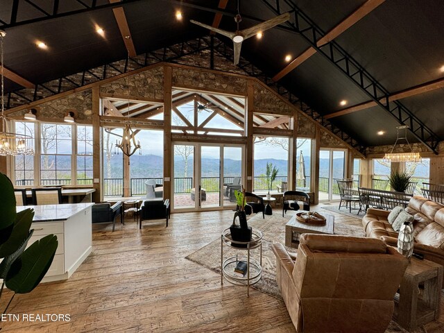550 Steer Creek Rd, Tellico Plains, TN 37385 - living room featuring ceiling fan with notable chandelier, wood-type flooring, a mountain view, and high vaulted ceiling