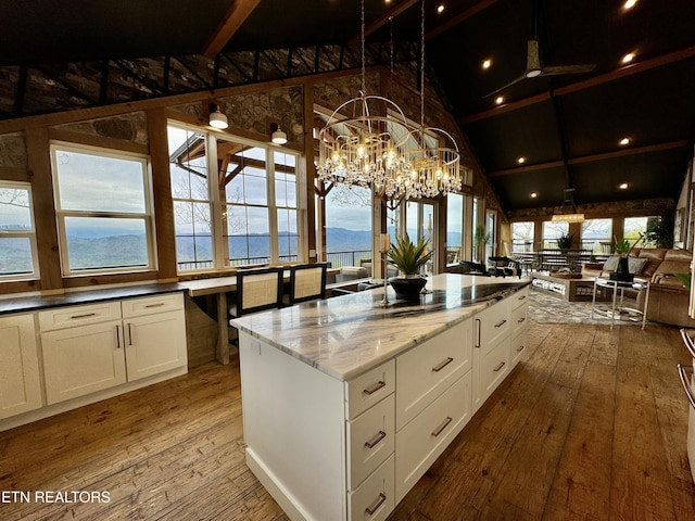550 Steer Creek Rd, Tellico Plains, TN 37385 - kitchen featuring a kitchen island, decorative light fixtures, white cabinetry, dark stone countertops, and light hardwood / wood-style floors