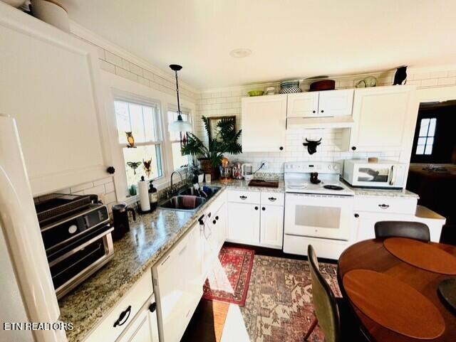 kitchen with pendant lighting, sink, white appliances, and white cabinetry