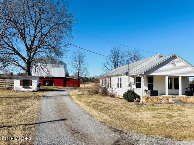 view of side of home featuring a yard and covered porch