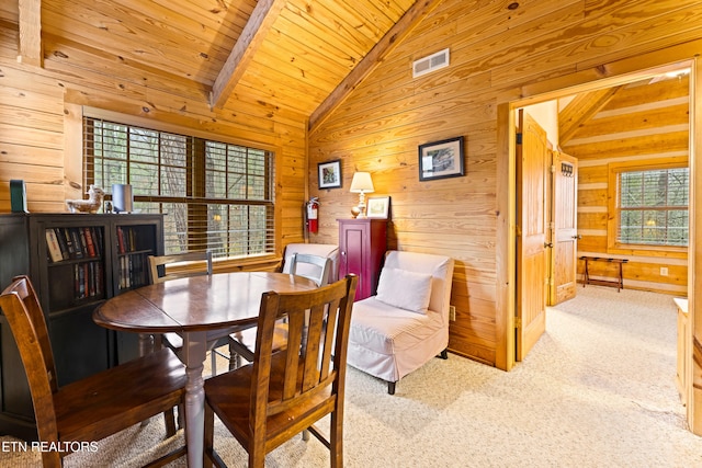 carpeted dining room featuring lofted ceiling with beams, wood ceiling, and wooden walls