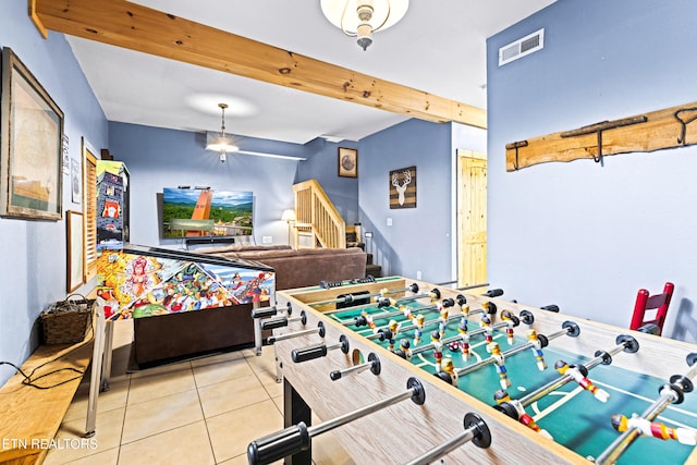 game room with beamed ceiling and tile patterned flooring