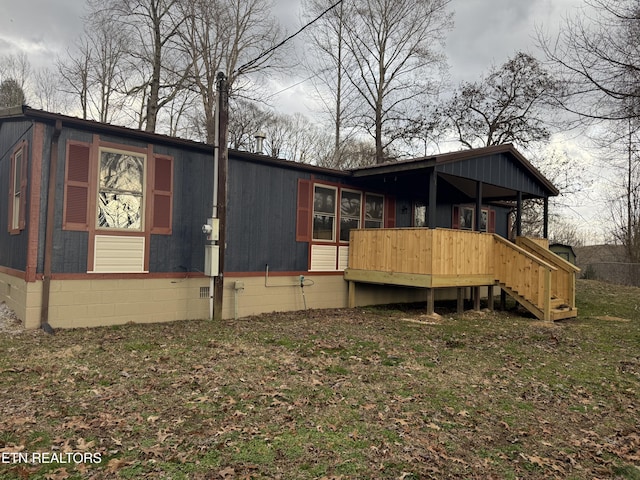 rear view of house featuring a deck and a lawn