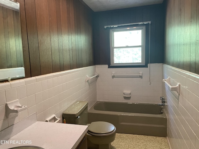 bathroom featuring vanity, tile walls, a tub, and toilet