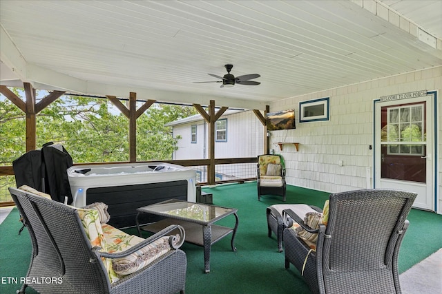 view of patio / terrace with a hot tub, an outdoor living space, and a ceiling fan