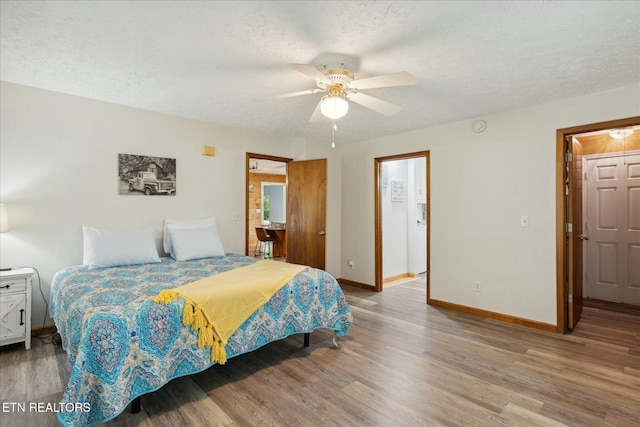 bedroom featuring a ceiling fan, baseboards, a textured ceiling, and light wood finished floors