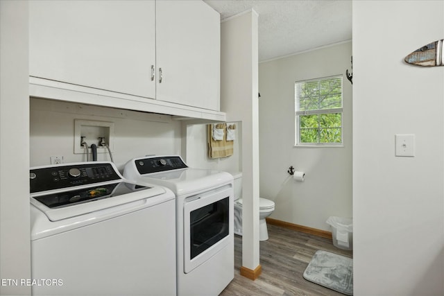 laundry room with washer and clothes dryer, light wood finished floors, a textured ceiling, laundry area, and baseboards