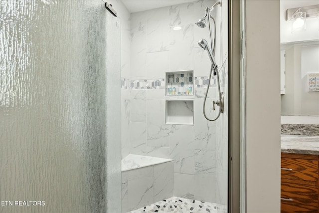 full bathroom with vanity and a marble finish shower