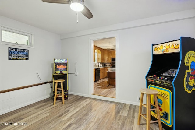 recreation room featuring light wood-style floors, baseboards, and a ceiling fan