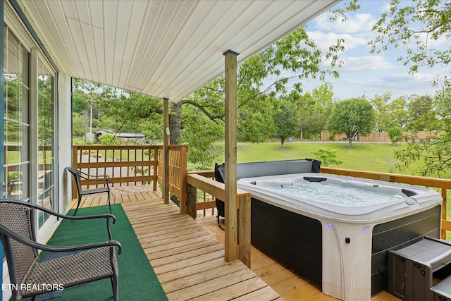 wooden deck featuring a hot tub and a lawn