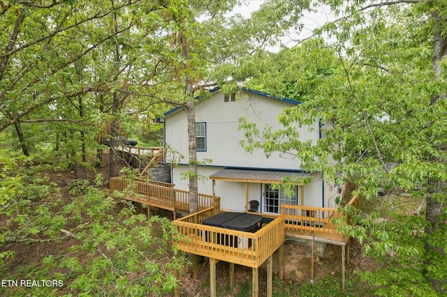 back of house featuring metal roof and a deck