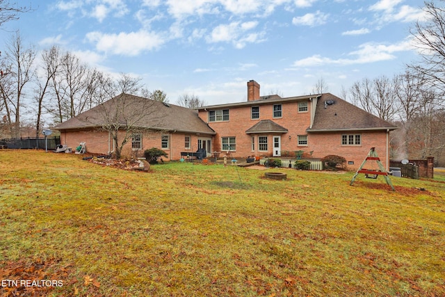 rear view of house featuring a yard