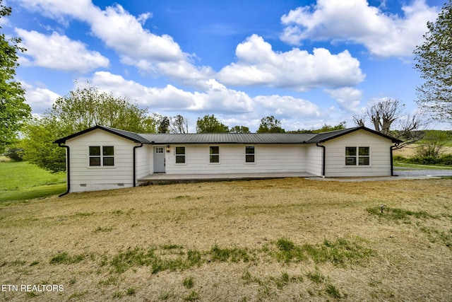 rear view of house featuring a yard