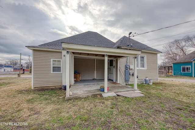 rear view of house featuring a lawn and a patio