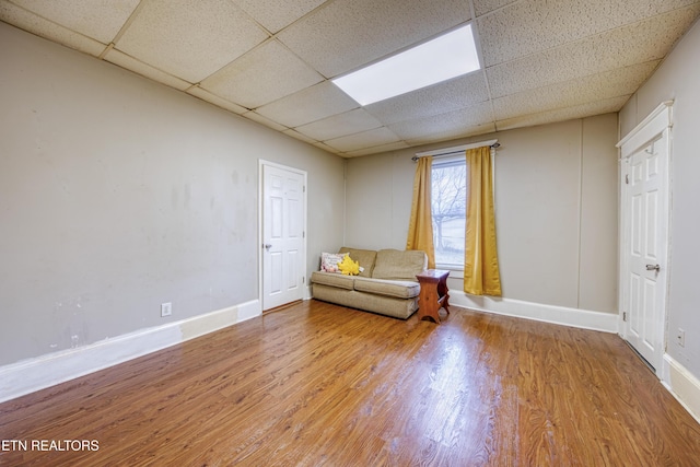 unfurnished room featuring hardwood / wood-style floors and a drop ceiling