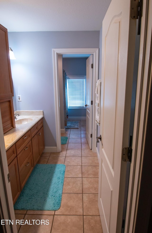 bathroom featuring tile patterned flooring, vanity, and a textured ceiling