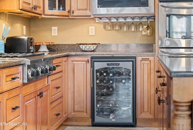 kitchen with light tile patterned floors, oven, and beverage cooler