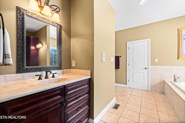 bathroom with vanity, tiled bath, and tile patterned flooring