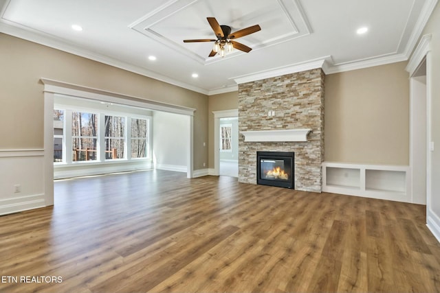 unfurnished living room featuring crown molding, ceiling fan, wood-type flooring, and a fireplace