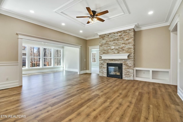 unfurnished living room featuring ceiling fan, wood-type flooring, crown molding, and a fireplace