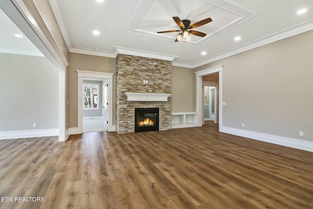 unfurnished living room with crown molding, a stone fireplace, and ceiling fan