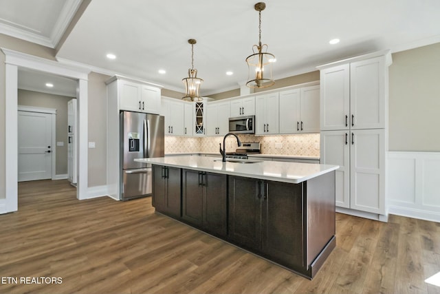 kitchen with white cabinetry, appliances with stainless steel finishes, sink, and decorative light fixtures