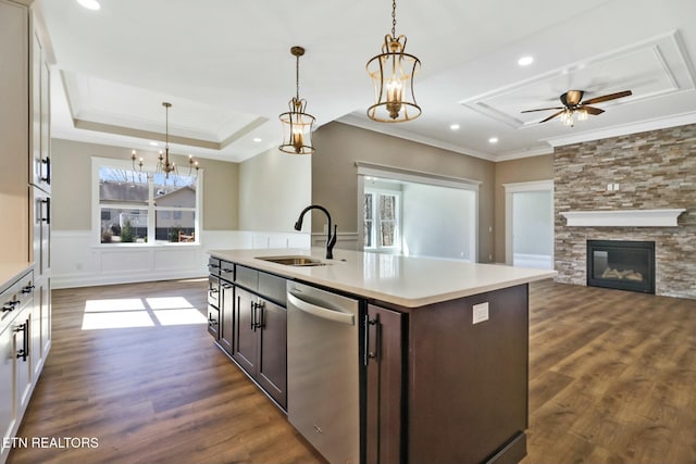 kitchen featuring dark brown cabinetry, sink, stainless steel dishwasher, a tray ceiling, and a kitchen island with sink