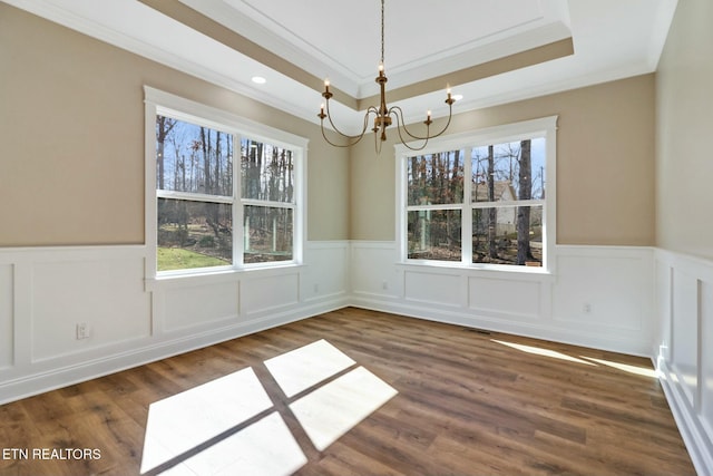 unfurnished dining area featuring dark wood-type flooring, a wealth of natural light, and a chandelier