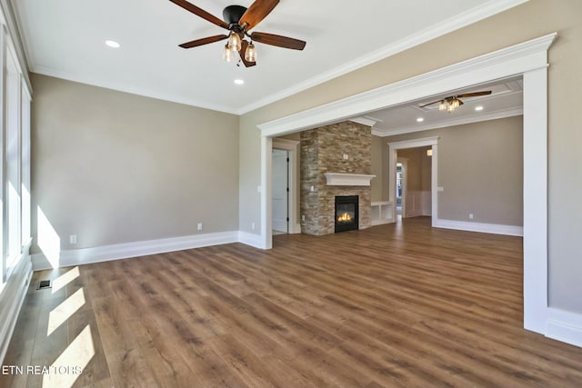 unfurnished living room featuring crown molding, a stone fireplace, and dark wood-type flooring