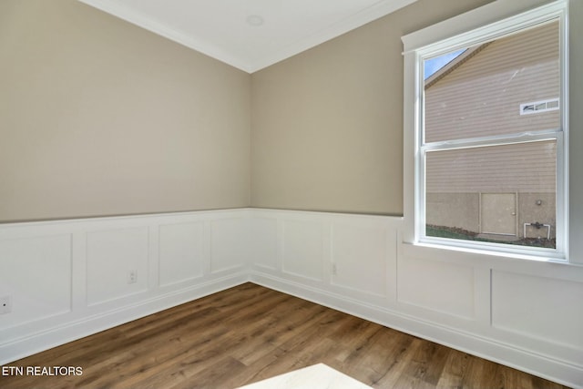 empty room featuring ornamental molding and wood-type flooring