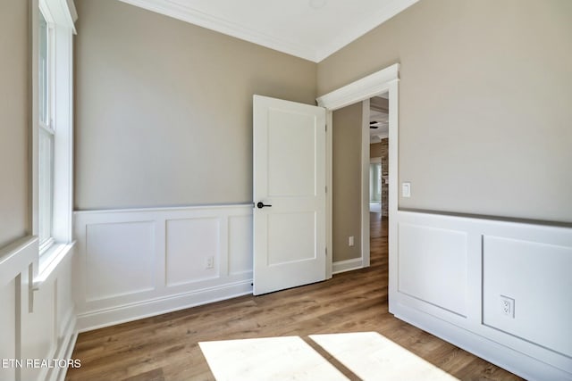 spare room with crown molding and hardwood / wood-style flooring