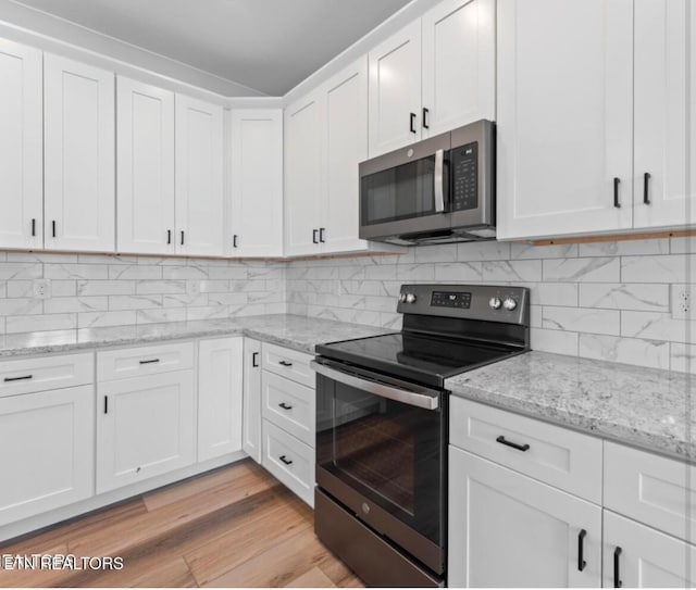 1094 W Glenview Dr, Lenoir City, TN 37771 - kitchen with white cabinetry, tasteful backsplash, light wood-style floors, light stone counters, and appliances with stainless steel finishes