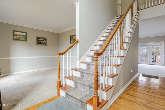 staircase with french doors, ornamental molding, wood-type flooring, and a towering ceiling