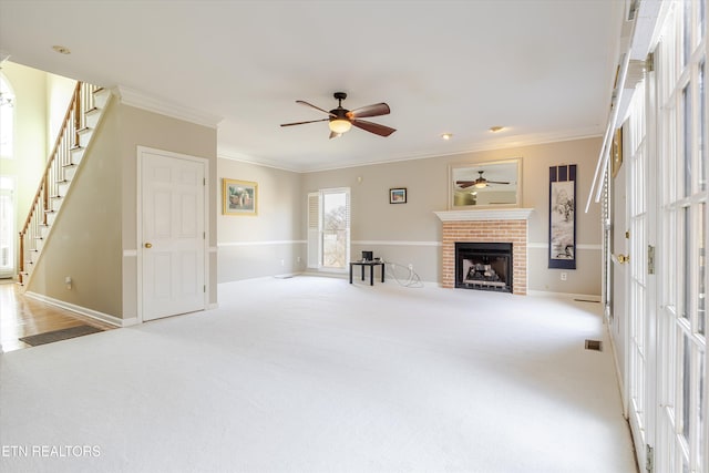 unfurnished living room with a brick fireplace, light colored carpet, ornamental molding, and ceiling fan