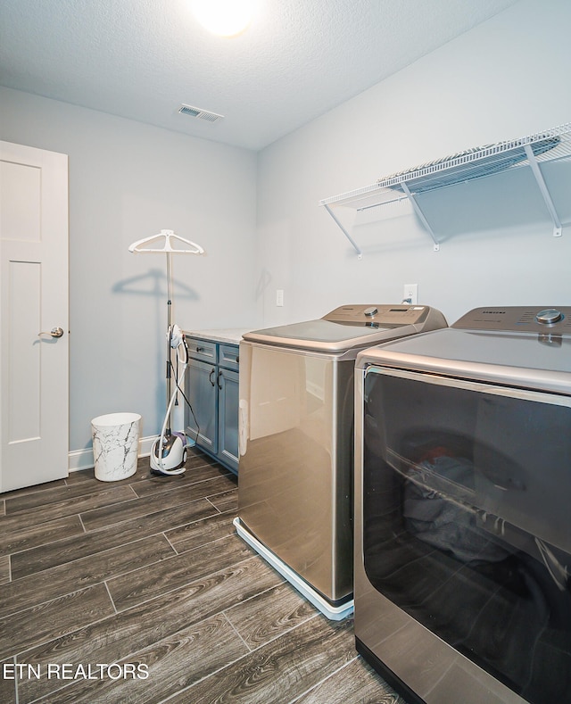 laundry room with cabinets, separate washer and dryer, and a textured ceiling