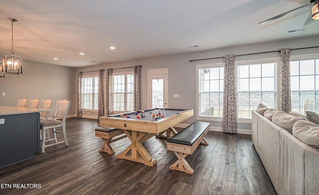 game room with dark hardwood / wood-style flooring and ceiling fan with notable chandelier