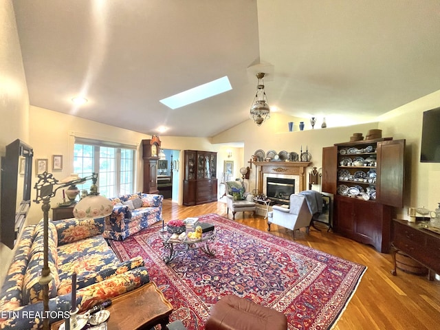 5001 Cheyenne Dr, Crossville, TN 38572 - living room with lofted ceiling, a skylight, a glass covered fireplace, and wood finished floors
