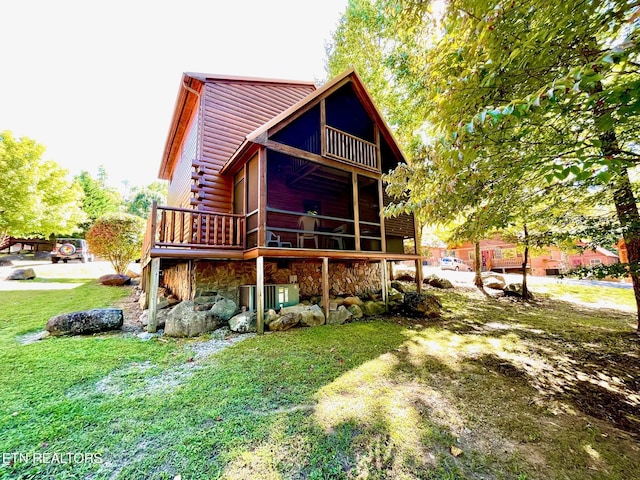 back of property with stone siding and a yard